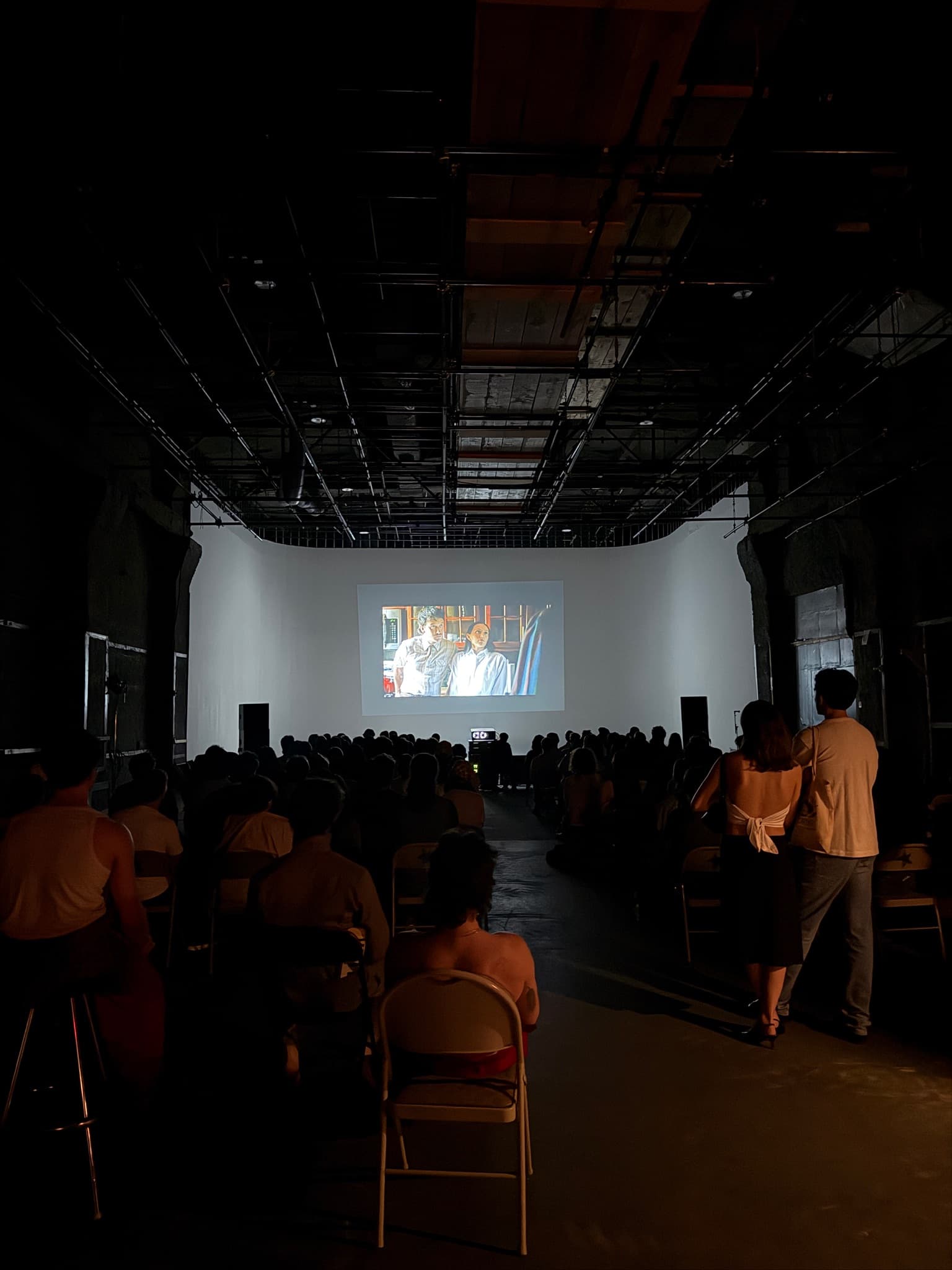 Audience watching a film screening in a dark room