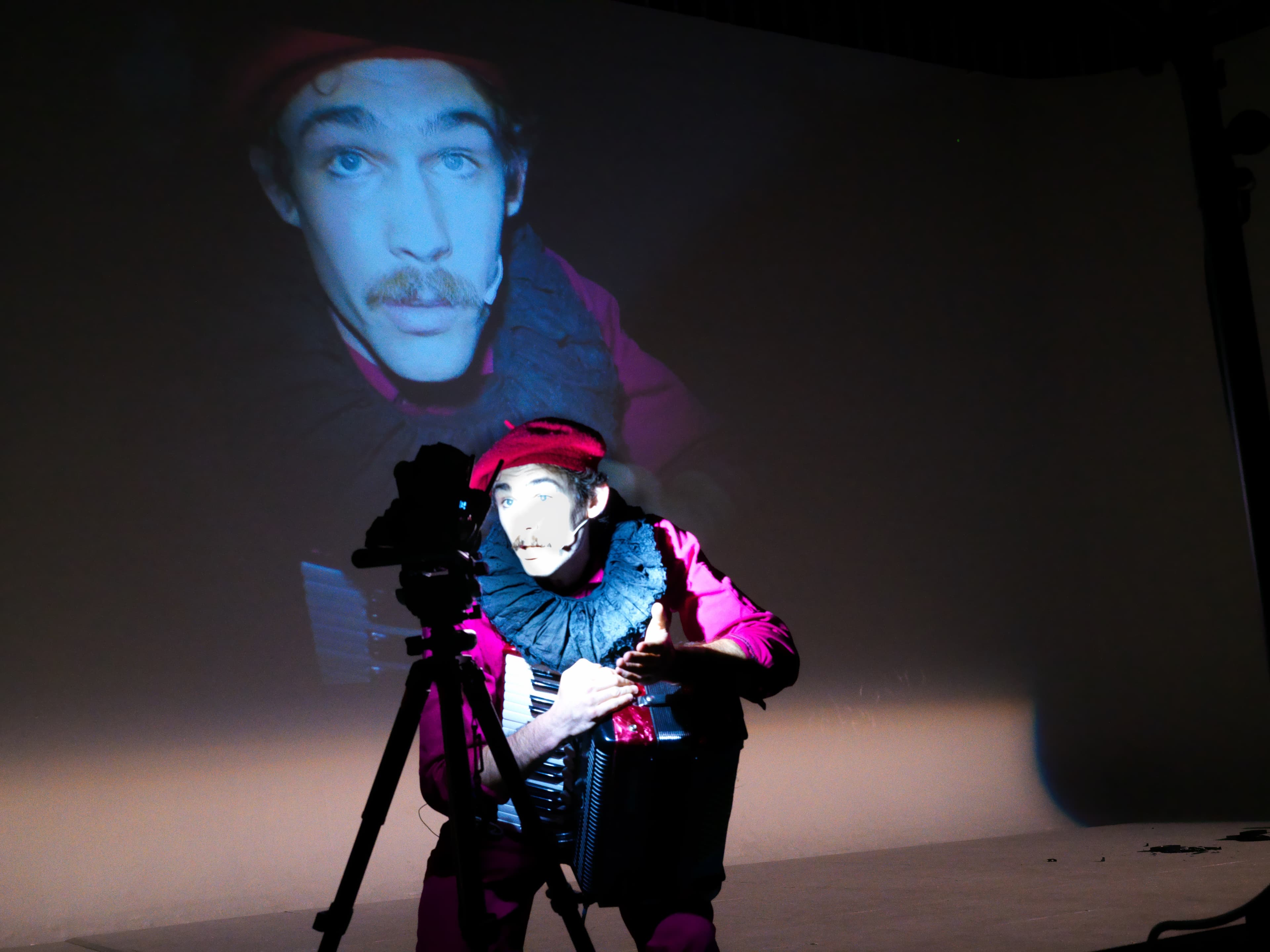 A live performer with his face projected behind him
